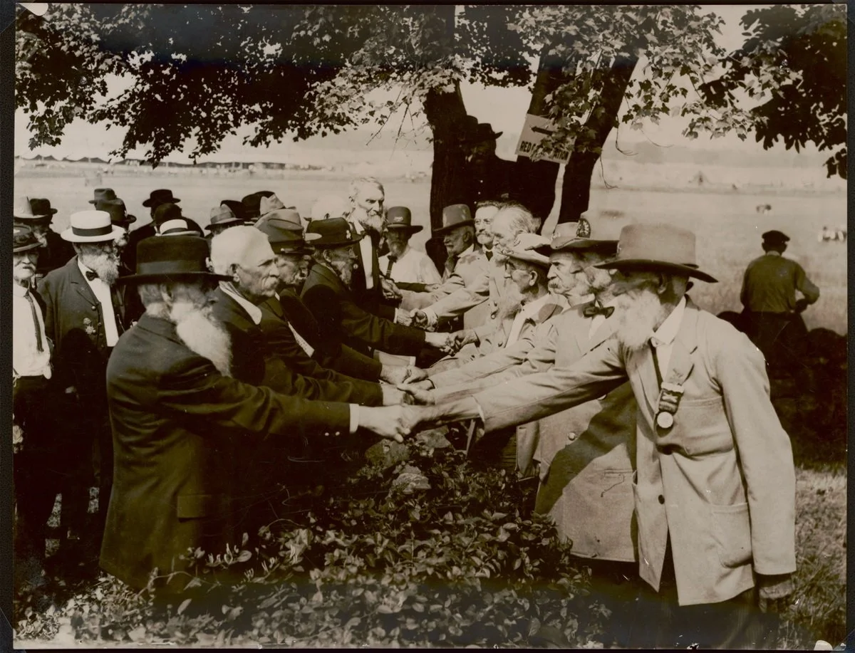 Union and Confederate veterans shaking hands at Blue-Gray reunion