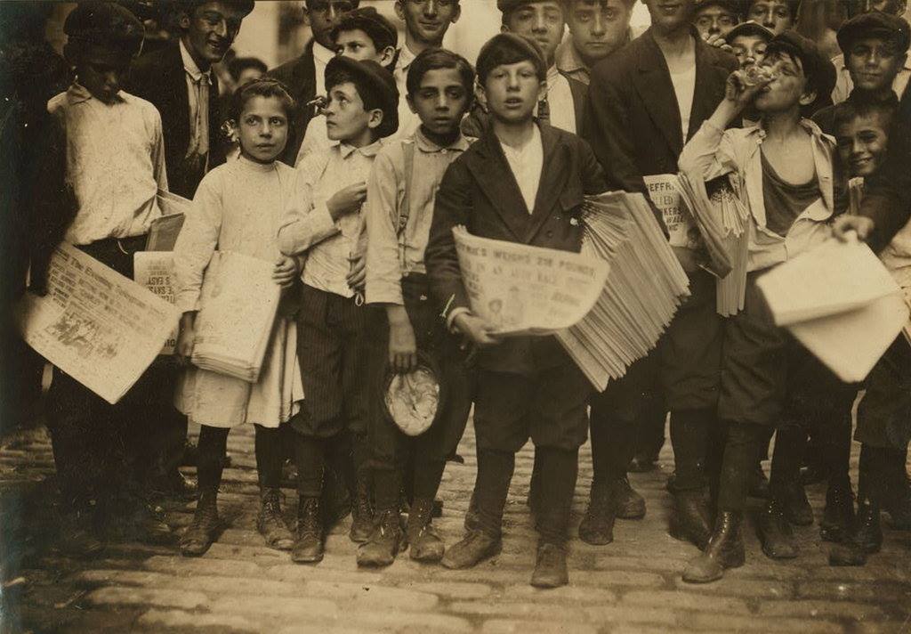 Newsboys selling papers on the streets of New York City during the 19th century